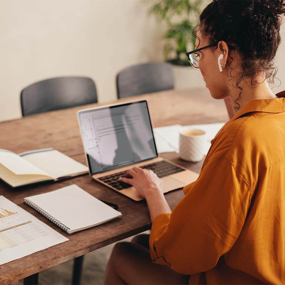 Femme en télétravail utilisant un accès Internet haut débit sécurisé, garantissant une connexion fluide et stable.